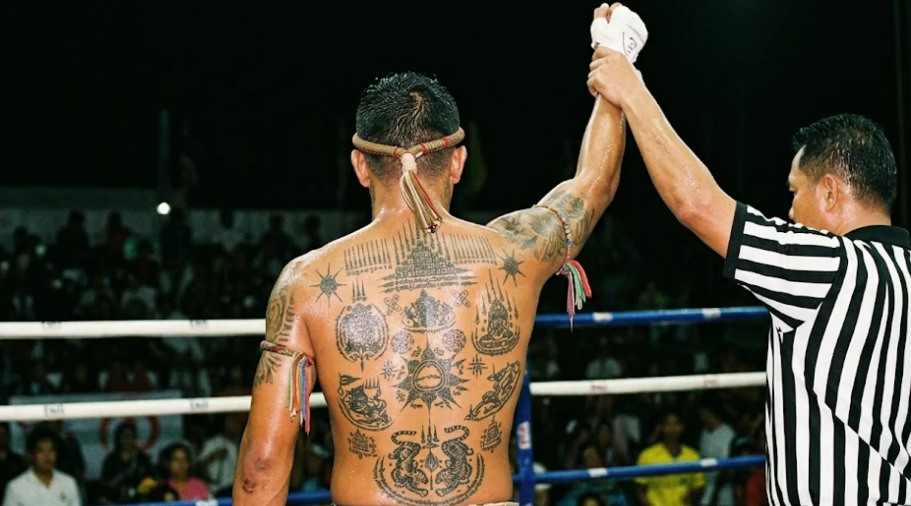 Shirtless man with sak yant tattoos visible on his body